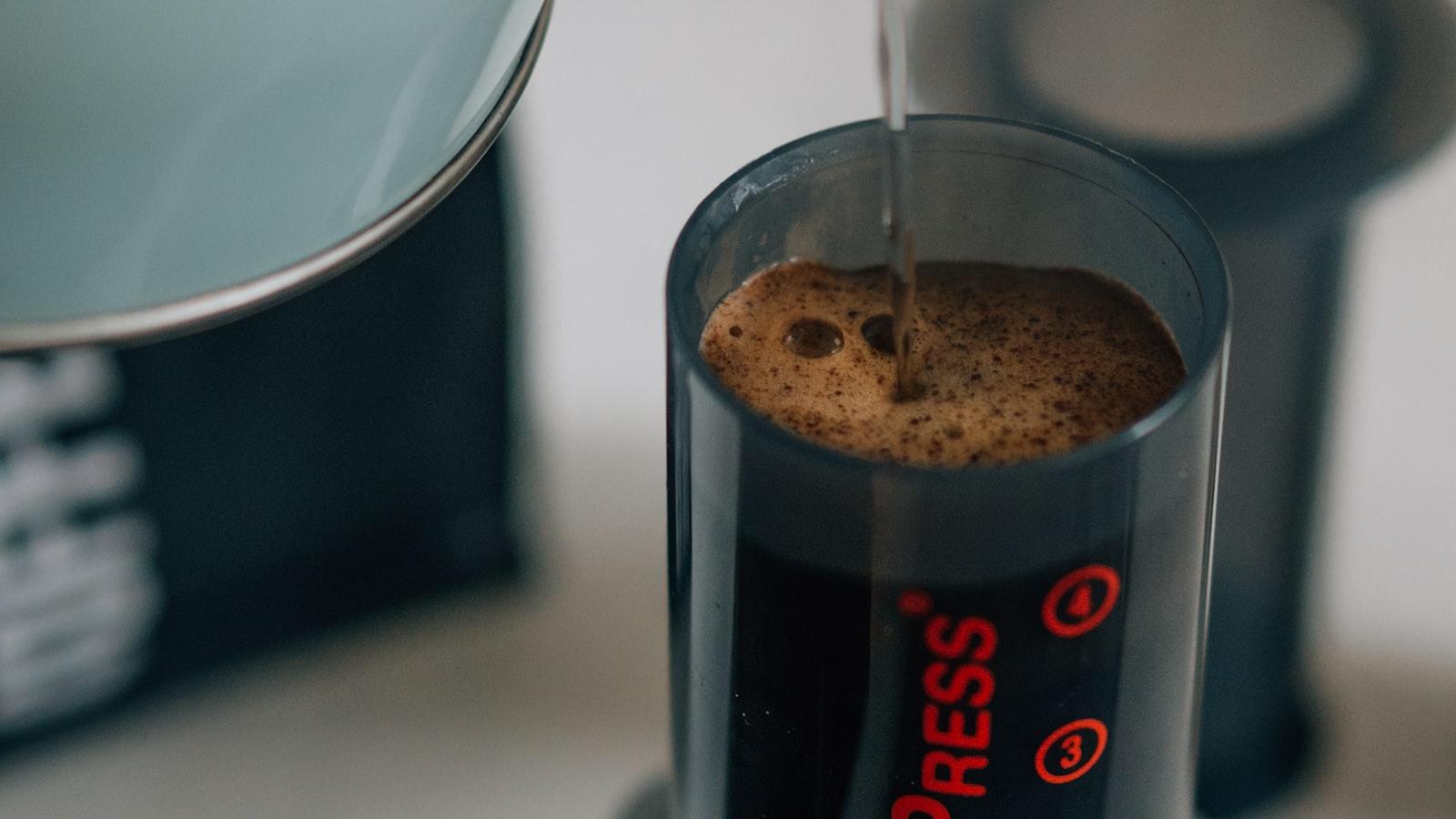 Hot water being poured into an AeroPress chamber, a head of crema forming on the coffee as it steeps
